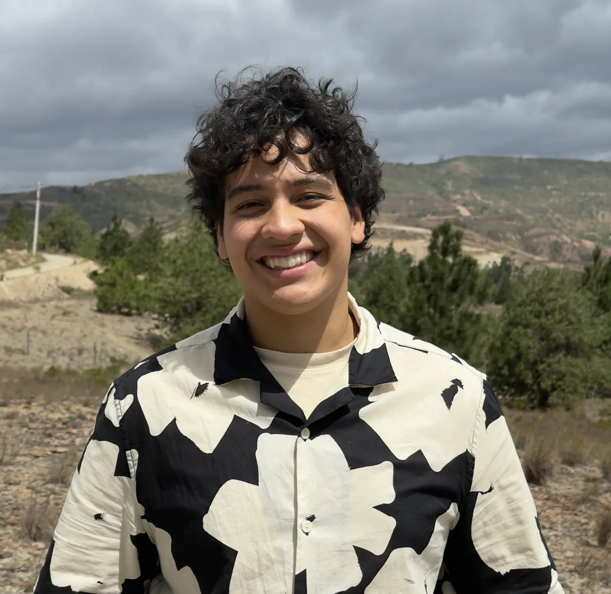 A phot of 线上赌博app student Nicolas Pinto in front of a hill with trees in the background