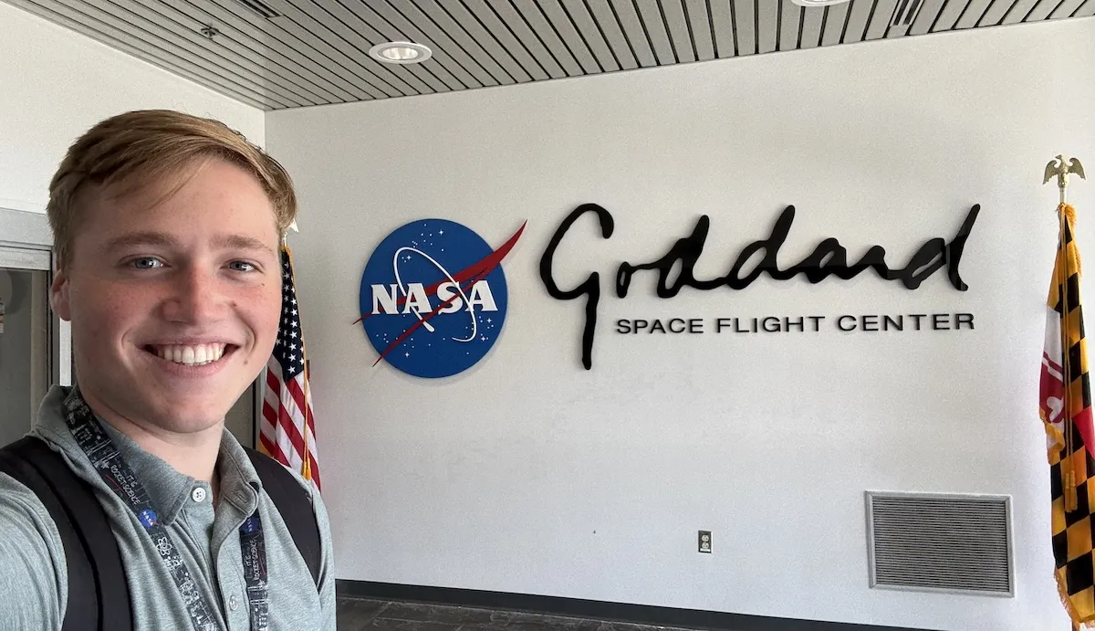 Turner Person posing in front of the sign for Goddard Space Flight Center