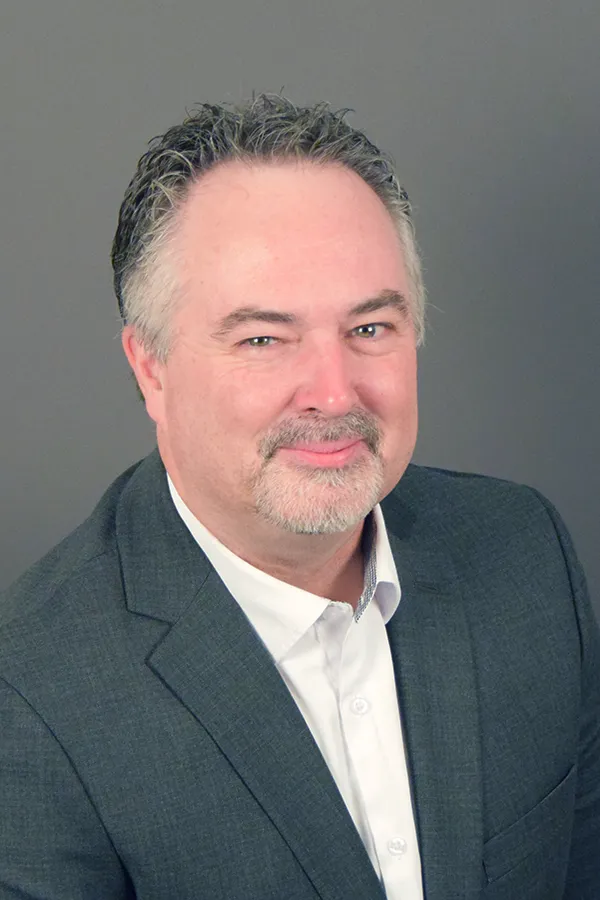 Sean Kelly smiling confidently at camera.