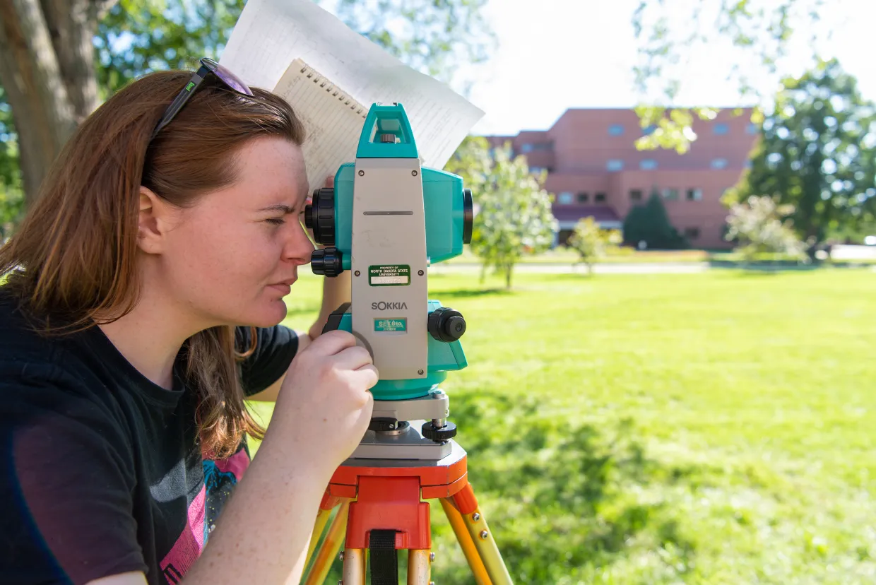 student uses a surveying tool
