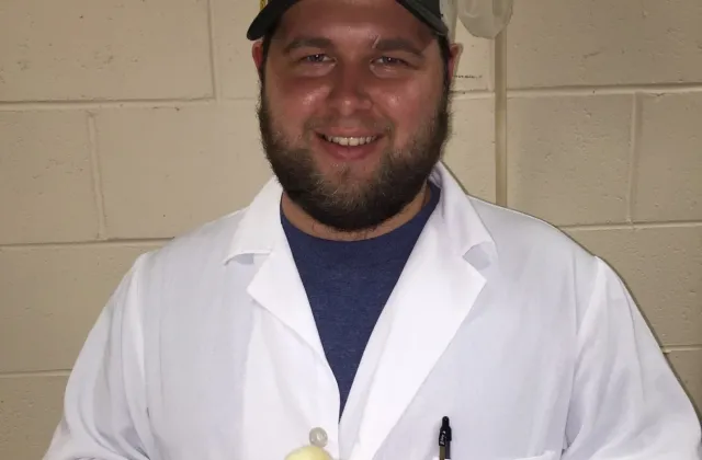 alumni holding a baby chick