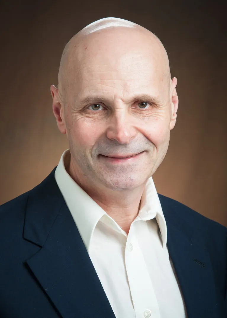 Ross is smiling at the camera